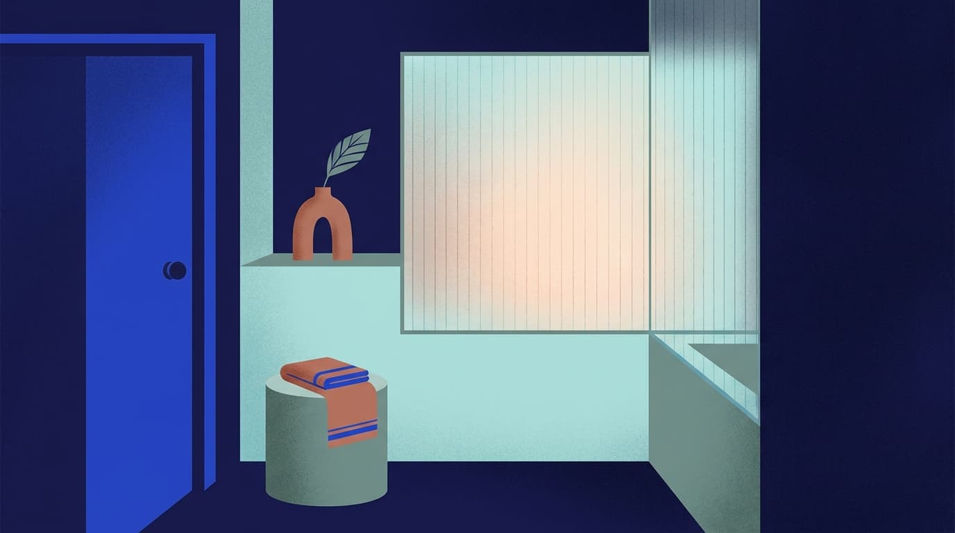 A quiet bathroom corner with a folded towel and soft daylight through frosted glass.