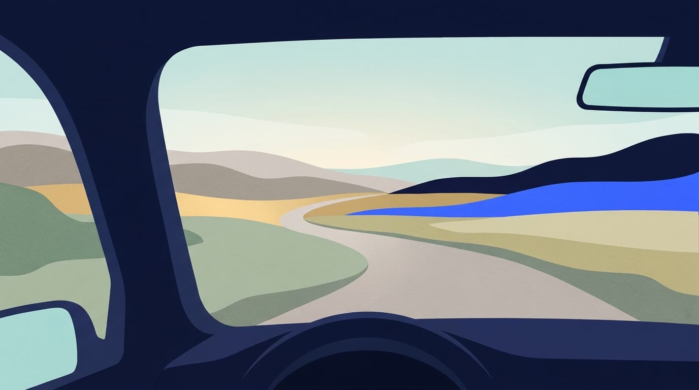 A quiet country road seen through a car windscreen in early morning light